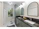 Elegant bathroom featuring dual sinks, black countertops, and ample natural light at 2223 Club Rd, Charlotte, NC 28205