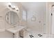 Clean and bright bathroom with a pedestal sink and classic black and white tile accents at 2223 Club Rd, Charlotte, NC 28205