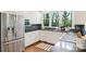 Well-lit kitchen features white cabinets, stainless steel appliances, and a view of the backyard at 2223 Club Rd, Charlotte, NC 28205