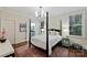 Spacious main bedroom features a four-poster bed, neutral decor, and access to the bathroom at 2223 Club Rd, Charlotte, NC 28205