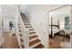Staircase with hardwood steps and white risers leading to the upper level and a bedroom at 2223 Club Rd, Charlotte, NC 28205