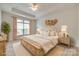 Staged primary bedroom featuring a tray ceiling, a decorative accent wall and neutral decor at 2261 Lincolnshire Ln, Waxhaw, NC 28173
