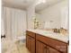Well-lit bathroom with granite countertops, wooden cabinets, and a shower-tub combination with floral shower curtain at 274 Cove Creek Loop, Mooresville, NC 28117