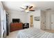Comfortable bedroom featuring a ceiling fan, desk, dresser with a TV, and ensuite bathroom, perfect for relaxation at 274 Cove Creek Loop, Mooresville, NC 28117