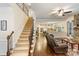 Open-concept living area with staircase and view of kitchen with white cabinets and hardwood floors at 274 Cove Creek Loop, Mooresville, NC 28117