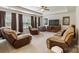 Spacious living room with plush seating, large windows with curtains, ceiling fan, and media center for entertainment at 274 Cove Creek Loop, Mooresville, NC 28117