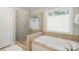 Well-lit bathroom featuring a soaking tub, glass enclosed shower, and tiled accents at 3112 Planters Ridge Rd, Charlotte, NC 28270