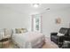 Cozy bedroom with a twin bed, reading chair, and window with backyard view at 3112 Planters Ridge Rd, Charlotte, NC 28270