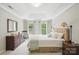 Well-lit bedroom with natural light, neutral tones, rocking chair, and matching nightstands offers space to unwind at 3112 Planters Ridge Rd, Charlotte, NC 28270