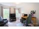 Bright bedroom featuring two windows, large television and a modern gaming chair at 3112 Planters Ridge Rd, Charlotte, NC 28270