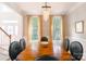 Elegant dining room featuring a long wooden table, seating for eight, and natural light from large windows at 3112 Planters Ridge Rd, Charlotte, NC 28270