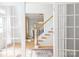 Elegant foyer with hardwood floors and glass paneled French doors that open to reveal the staircase at 3112 Planters Ridge Rd, Charlotte, NC 28270