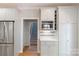 Kitchen featuring white cabinetry, stainless steel microwave, and easy access to the staircase at 3112 Planters Ridge Rd, Charlotte, NC 28270
