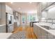 Well-lit kitchen featuring gray cabinets, stainless steel appliances, and hardwood flooring at 3112 Planters Ridge Rd, Charlotte, NC 28270