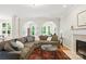Bright living room featuring a cozy fireplace, large sectional, and arched doorways at 3112 Planters Ridge Rd, Charlotte, NC 28270