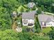 Aerial view showcasing the home's backyard with a fire pit, trampoline, playset, deck and lush landscaping at 3609 Benseval Ln, Matthews, NC 28105