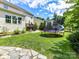 Well-maintained backyard featuring a trampoline, playhouse, lush green lawn, and a glimpse of the home's exterior at 3609 Benseval Ln, Matthews, NC 28105