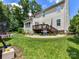 Expansive backyard featuring a deck, grill, stone accents, and lush green lawn, ideal for entertaining or relaxing outdoors at 3609 Benseval Ln, Matthews, NC 28105