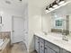 Bright bathroom with double sinks, gray cabinets, and tile flooring, offering plenty of counter space at 3609 Benseval Ln, Matthews, NC 28105