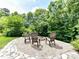 Backyard firepit area surrounded by gravel and stone, featuring Adirondack style seating perfect for relaxing at 3609 Benseval Ln, Matthews, NC 28105