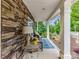 Inviting front porch with stone accent wall, cushioned seating, and a vibrant outdoor rug at 3609 Benseval Ln, Matthews, NC 28105