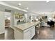 Open kitchen with white cabinets and a granite countertop island overlooking the living room at 3609 Benseval Ln, Matthews, NC 28105