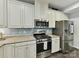 Bright kitchen featuring stainless steel appliances, granite countertops, and white cabinets at 3609 Benseval Ln, Matthews, NC 28105