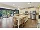 Open kitchen with stainless appliances, white cabinetry, and island seating overlooking a sitting area at 3609 Benseval Ln, Matthews, NC 28105