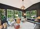 Bright sunroom with dark walls, large windows, stylish furnishings, and a modern light fixture at 3609 Benseval Ln, Matthews, NC 28105