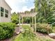 Backyard swing hanging from a pergola amidst lush greenery, creating a serene and inviting outdoor space at 3609 Benseval Ln, Matthews, NC 28105