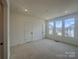 Sunlit bedroom featuring neutral carpet and a large window, creating a welcoming space at 3618 S Tryon St # 19, Charlotte, NC 28217
