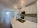 Bright kitchen featuring a quartz island with sink, pendant lighting, and stainless steel appliances at 3618 S Tryon St # 19, Charlotte, NC 28217