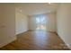 Spacious living room with wood floors and sliding glass door to balcony, offering natural light at 3618 S Tryon St # 19, Charlotte, NC 28217