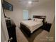 Cozy bedroom with a comfortable queen-sized bed, dark furniture, and soft natural light at 3816 Rosewood Dr, Mount Holly, NC 28120