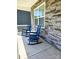 A front porch with two chairs set against a stone facade, perfect for relaxing outdoors at 3816 Rosewood Dr, Mount Holly, NC 28120