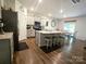 Open-concept kitchen with stainless steel appliances, a center island with seating, and adjacent dining area at 3816 Rosewood Dr, Mount Holly, NC 28120