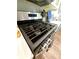 Close up of stainless steel gas range with towel rack and modern gray tile backsplash at 3816 Rosewood Dr, Mount Holly, NC 28120