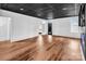 Finished basement is bright and airy with wood look floors, modern black ceiling, and a glimpse of a doorway to another room at 394 Stonecliff Ln, Clover, SC 29710
