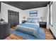 A calming bedroom design with black closet doors, hardwood style floors, and a modern blue bed at 394 Stonecliff Ln, Clover, SC 29710