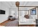 Bright bedroom featuring a four-poster bed, wood floors, decorative chandelier, and a comfortable lounge chair with throw at 394 Stonecliff Ln, Clover, SC 29710