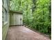 Backyard shed with door, concrete patio, and dense trees at 3941 Briarhill Dr, Charlotte, NC 28215