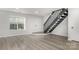 Bright, updated living room with neutral walls, modern flooring, and staircase leading to upper level at 3941 Briarhill Dr, Charlotte, NC 28215