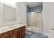 Bathroom with blue-tiled floor, blue-tiled shower stall and light wood vanity with white top and mirror at 441 Vermilion Dr, York, SC 29745