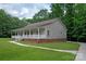 Landscaped house with a covered porch, white railings, green lawn, and long concrete driveway at 441 Vermilion Dr, York, SC 29745