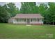 Charming home featuring a covered porch with white railings, a brick foundation, and lush green lawn at 441 Vermilion Dr, York, SC 29745