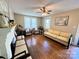 Bright living room with hardwood floors, a fireplace, and a ceiling fan at 450 1St Se St, Hickory, NC 28602