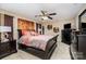 This primary bedroom features a ceiling fan, large bed, dark furniture, and neutral walls at 611 Sawtooth Oak Dr, Landis, NC 28088