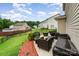 Inviting patio area with wicker furniture, barbecue grill, and manicured lawn at 611 Sawtooth Oak Dr, Landis, NC 28088