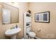 A powder room featuring a pedestal sink, toilet, medicine cabinet and artwork at 611 Sawtooth Oak Dr, Landis, NC 28088