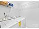 Convenient laundry area features white washer and dryer, plus handy shelving for storage and supplies at 6128 Warrior Ave, Fort Mill, SC 29707
